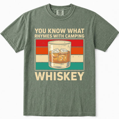 Moss green t-shirt featuring a retro graphic design with the text 'YOU KNOW WHAT RHYMES WITH CAMPING WHISKEY' and an illustration of an iced whiskey glass against a striped background.