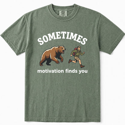 Moss green t-shirt featuring a graphic print of a brown bear and a hiking trail runner with the text 'SOMETIMES motivation finds you' in white.