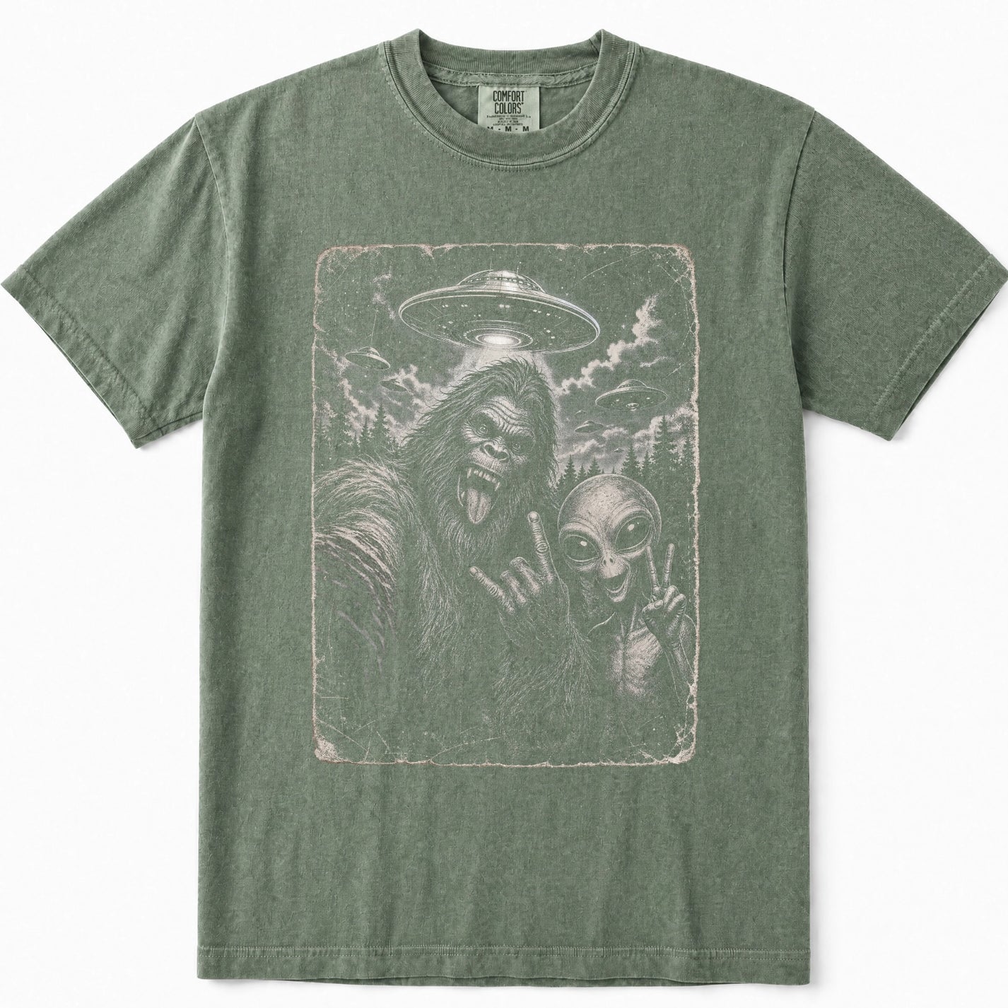 Moss green short-sleeve t-shirt featuring a distressed graphic print of Bigfoot and an alien in a UFO scene on the front.