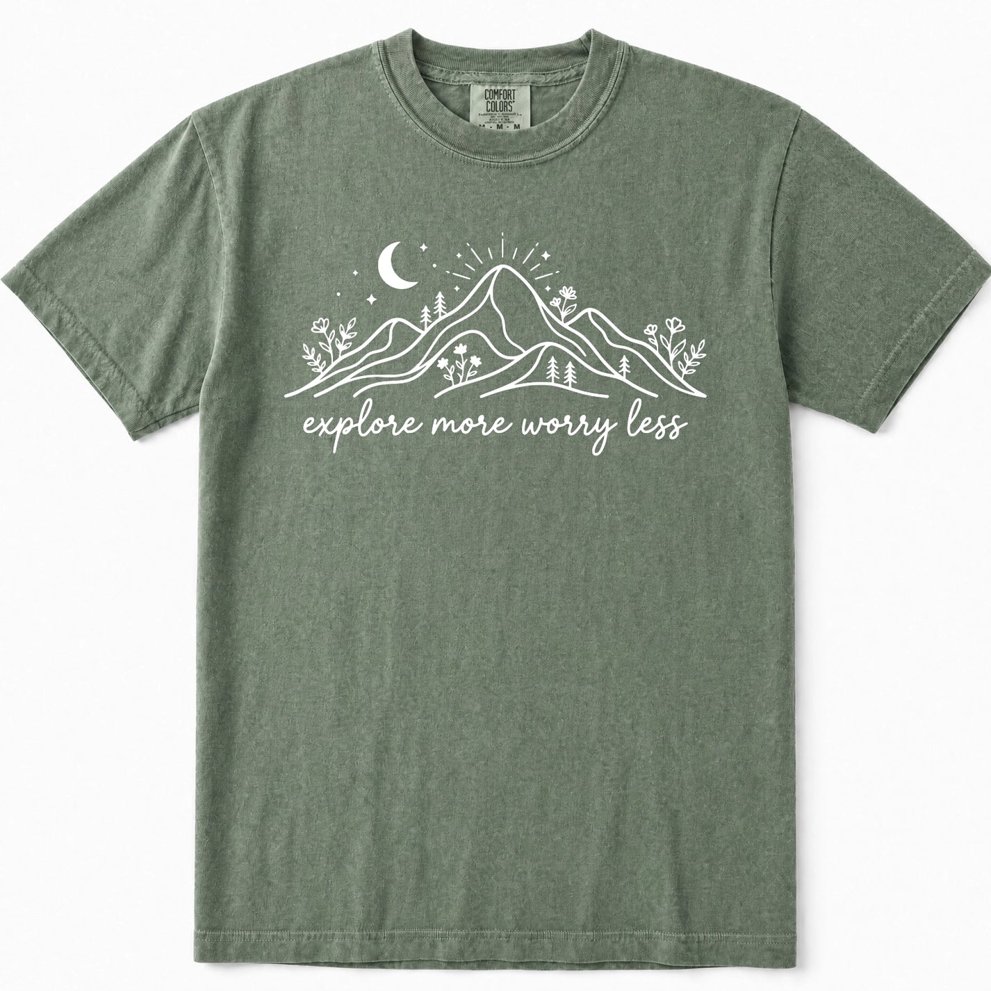 Moss green crewneck t-shirt with a white graphic of mountains, a crescent moon, and the text 'explore more worry less' printed on the chest.