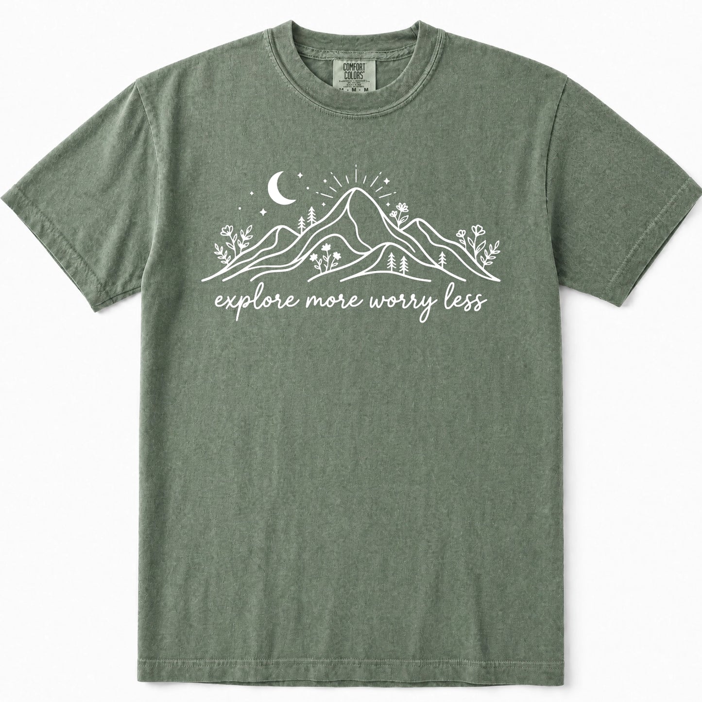 Moss green crewneck t-shirt with a white graphic of mountains, a crescent moon, and the text 'explore more worry less' printed on the chest.