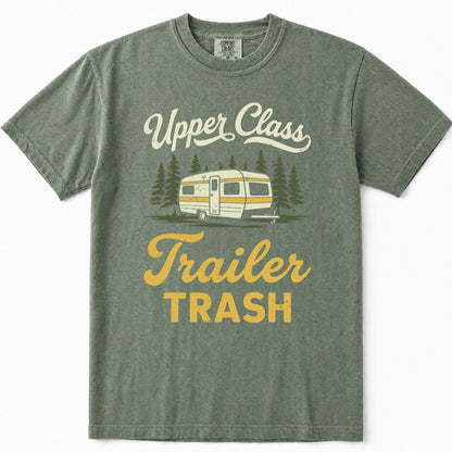 Moss green crewneck t-shirt featuring a retro graphic of a cream and yellow camper trailer surrounded by pine trees, with the text 'Upper Class Trailer TRASH' in cream and yellow lettering.