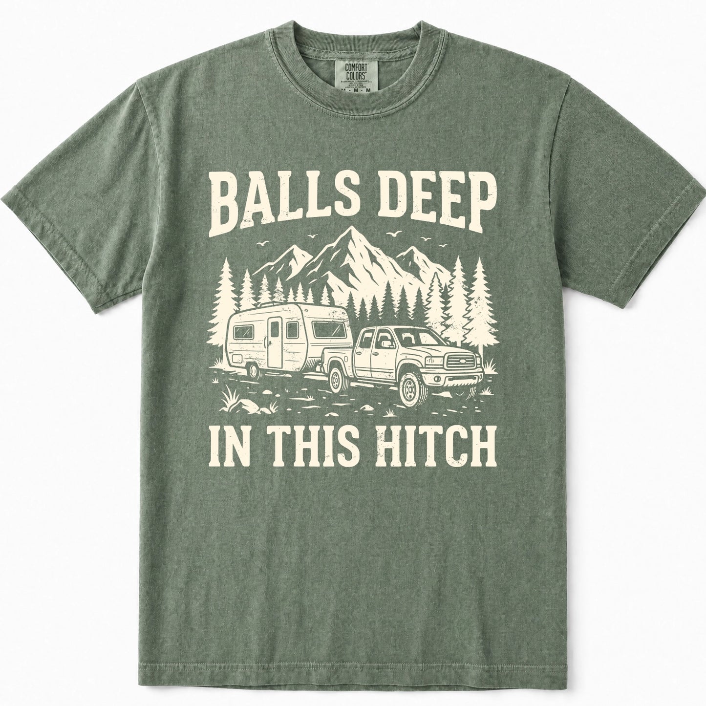 Moss green crewneck t-shirt featuring a vintage-style cream graphic of a pickup truck towing an RV with mountains and pine trees in the background, and the text 'BALLS DEEP IN THIS HITCH'.