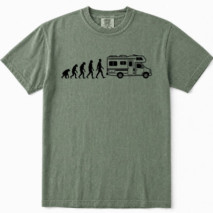 Moss green crewneck t-shirt featuring a black graphic print of the evolution of man leading up to a walking person next to a camper RV, displayed on a clean white background.