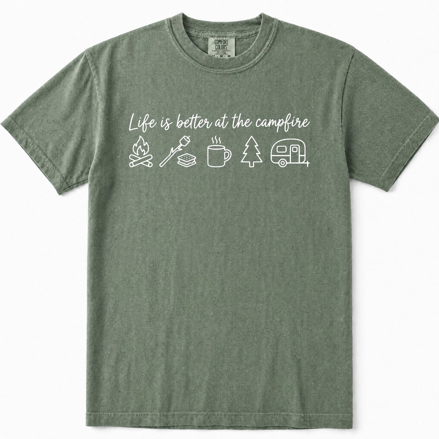 Moss green short-sleeve t-shirt with a white graphic print on the chest that reads 'Life is better at the campfire' above simple camping icons including a campfire, marshmallow, mug, tree, and camper. The shirt is displayed flat against a clean white background.