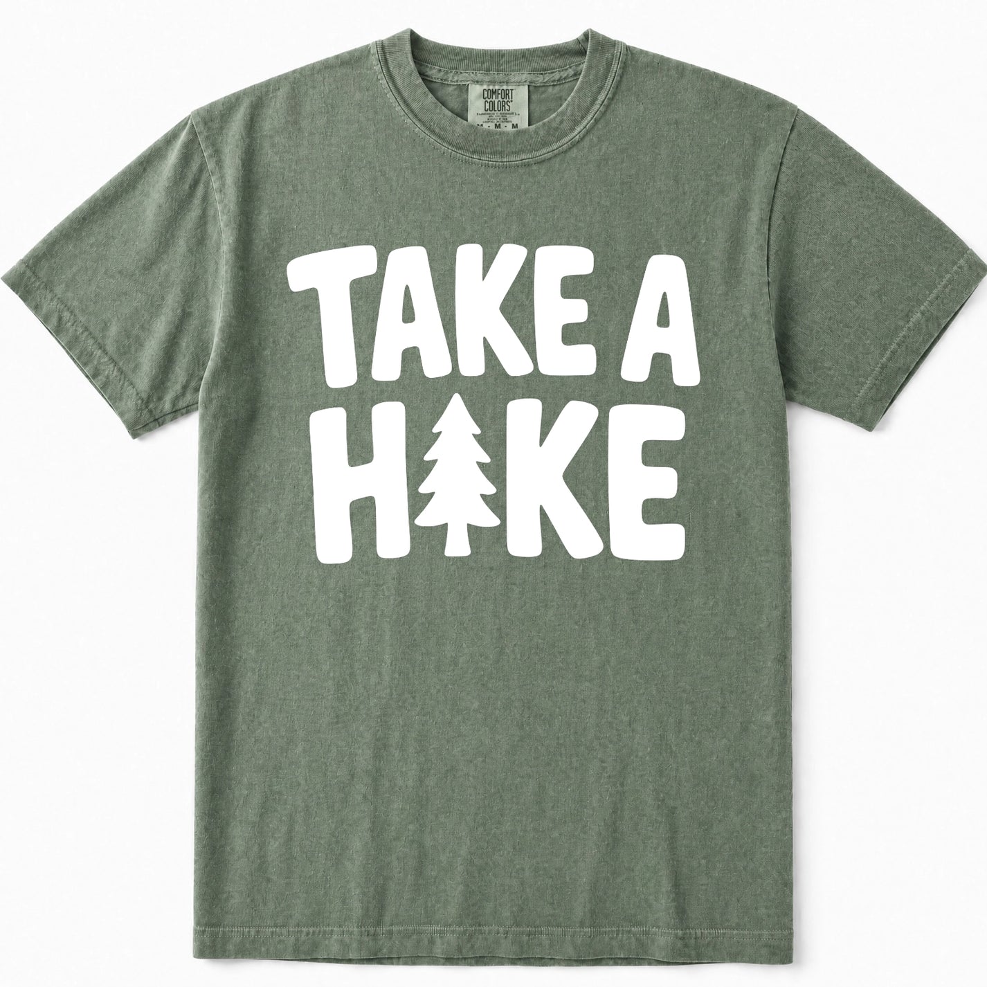 Moss green short-sleeve t-shirt with a bold white graphic print reading 'TAKE A HIKE' where the letter 'I' is replaced by a pine tree silhouette, shown flat against a white background.