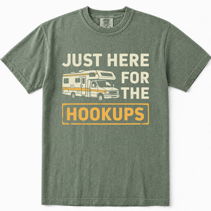 Moss green crewneck t-shirt featuring a vintage-style graphic print of a camper van and the text 'JUST HERE FOR THE HOOKUPS' in cream and yellow.