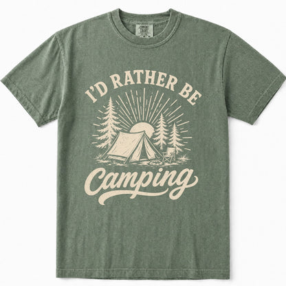 Moss green crewneck t-shirt featuring a cream-colored graphic print that reads 'I'D RATHER BE Camping' with an illustration of a tent, pine trees, and a sun.