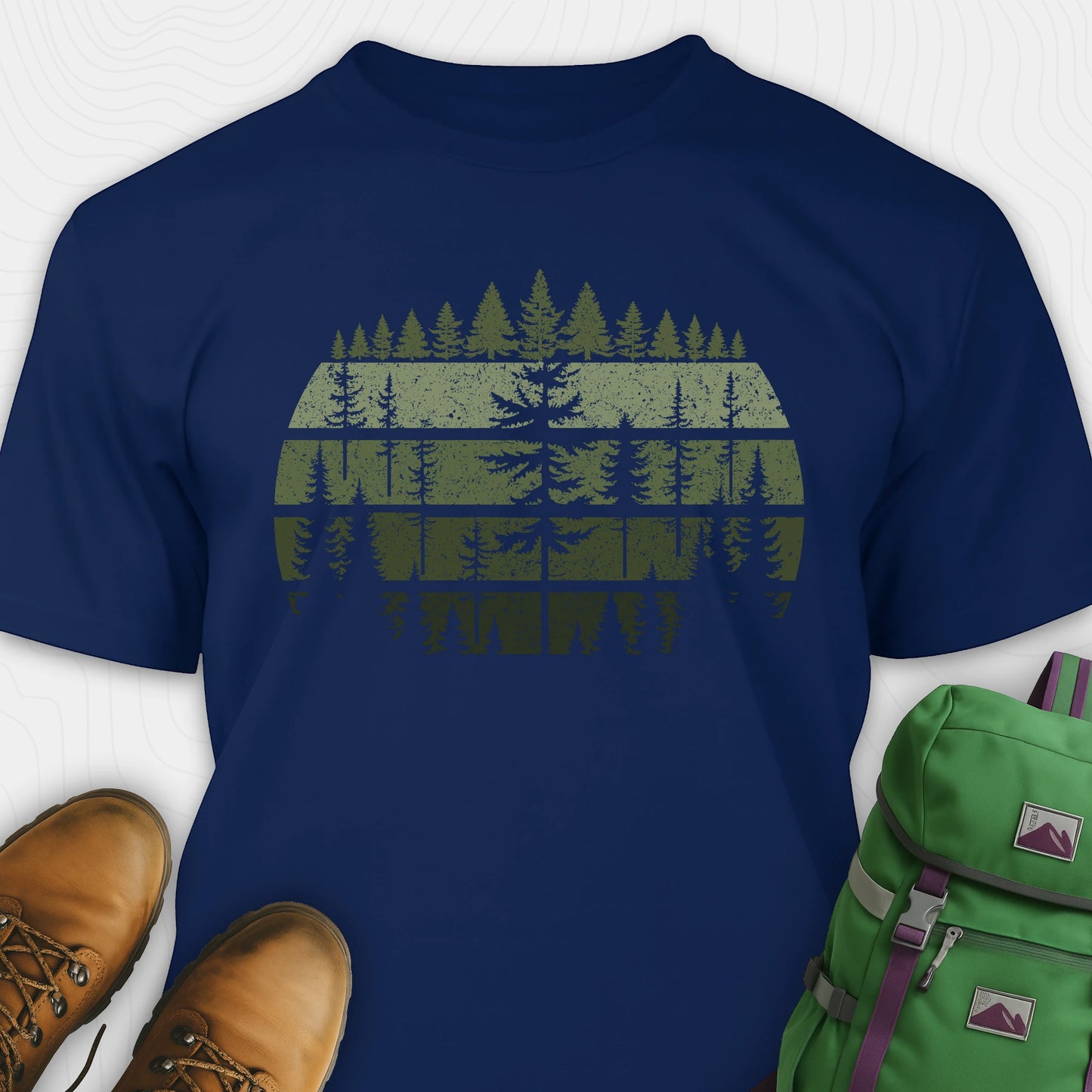 Navy forest shirt with distressed pine tree design, and green backpack on a white background