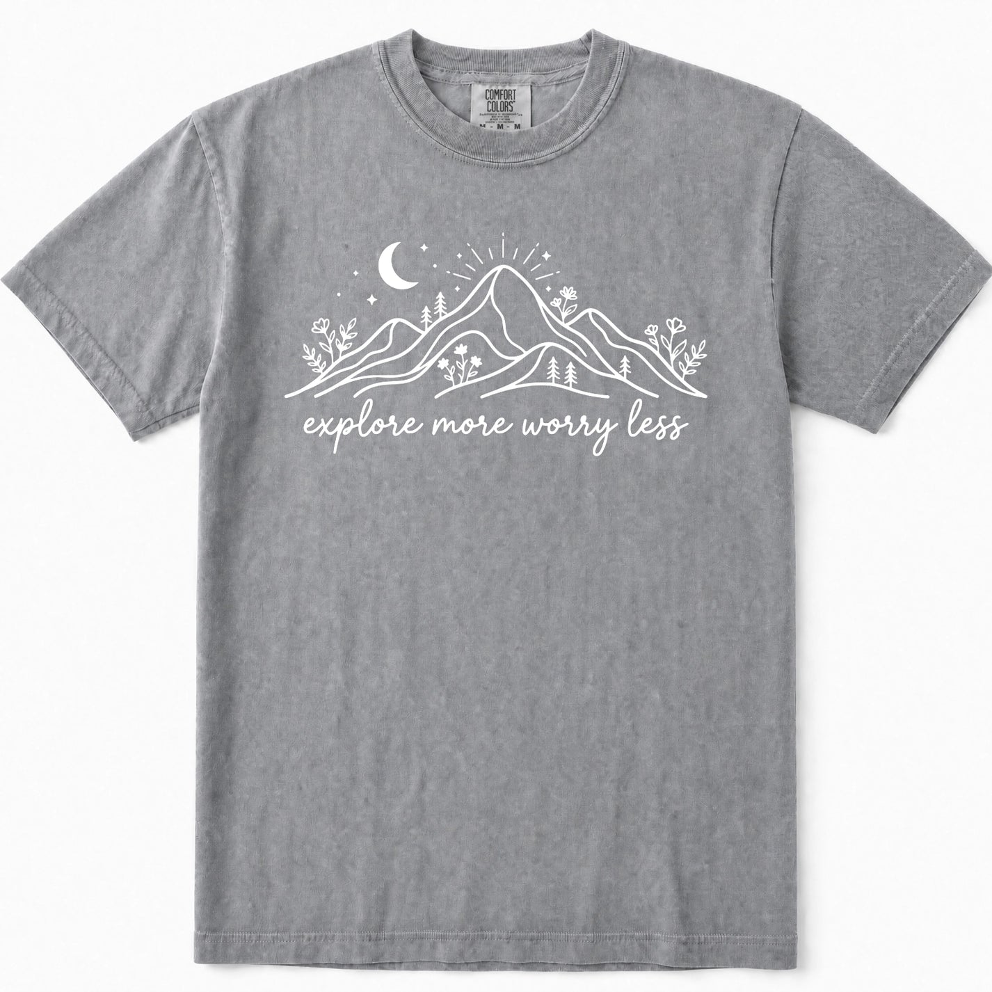Grey short-sleeve crewneck t-shirt with a white graphic of mountains, a crescent moon, and the text 'explore more worry less' printed on the chest.