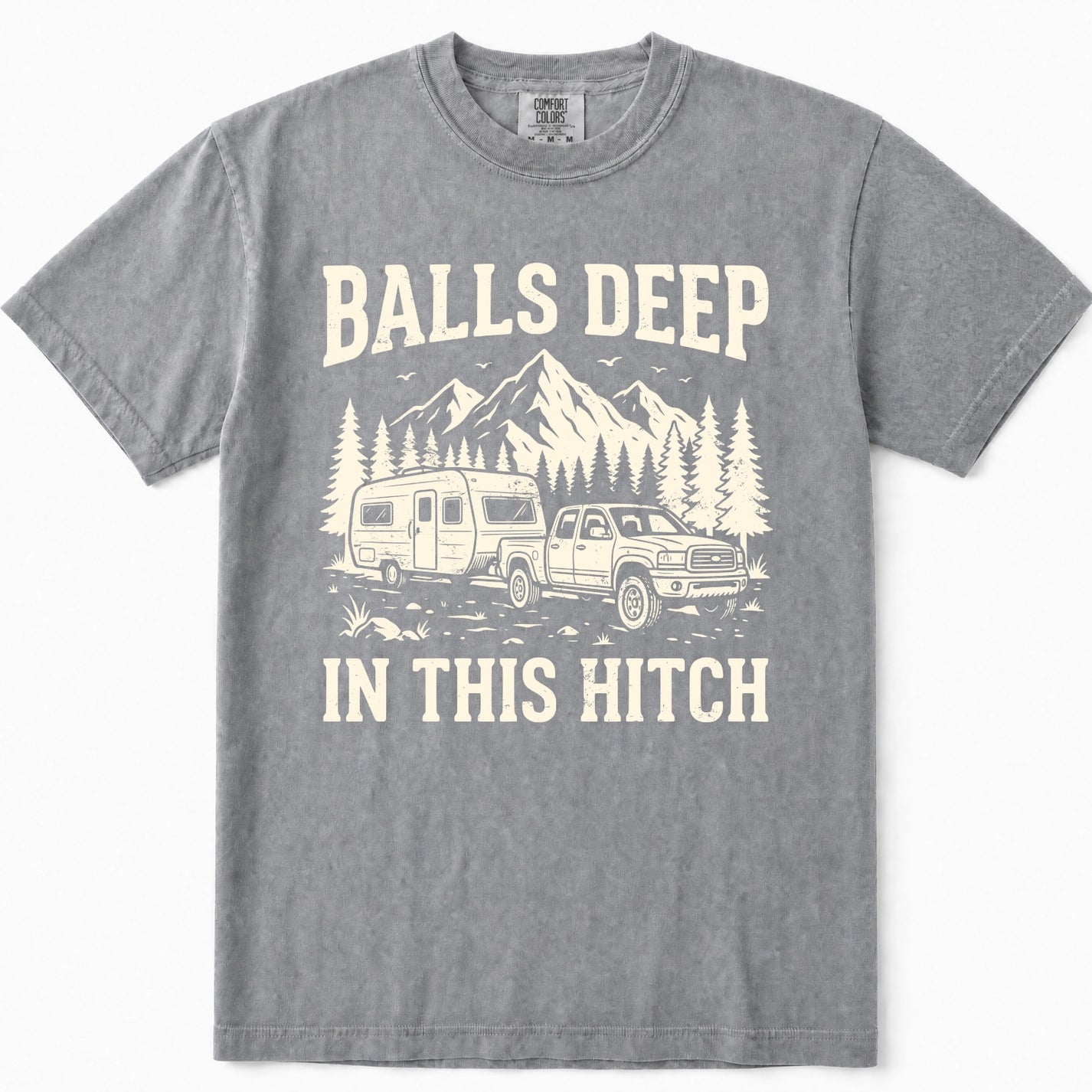 Grey crewneck t-shirt featuring a cream-colored graphic print of a pickup truck towing a camper trailer in front of mountains and pine trees, with the text 'BALLS DEEP IN THIS HITCH'.