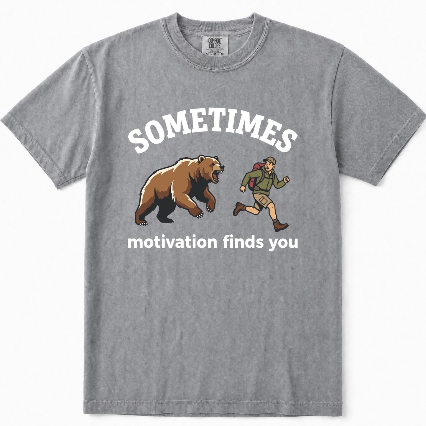 Grey crewneck t-shirt featuring a graphic print of a brown grizzly bear and a hiking trail runner with the text 'SOMETIMES motivation finds you' in white.