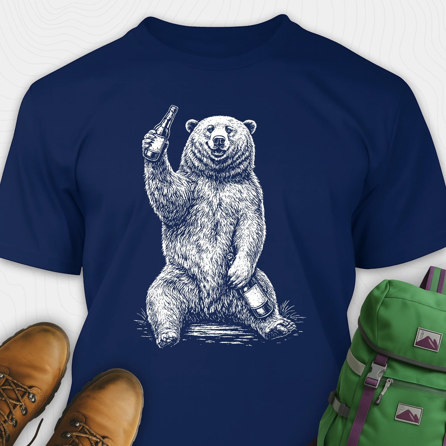 Navy brown bear shirt with a bear graphic holding a beer bottle, paired with brown shoes and a green backpack on a white background.