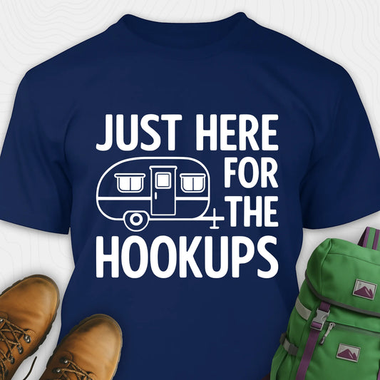 Navy hook ups t-shirt with trailer graphic and funny camping quote, paired with brown boots and a green backpack on a white background.