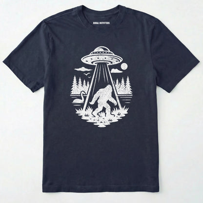 Navy monster shirt with Bigfoot, a forest scene, and a UFO beam graphic on a white background.