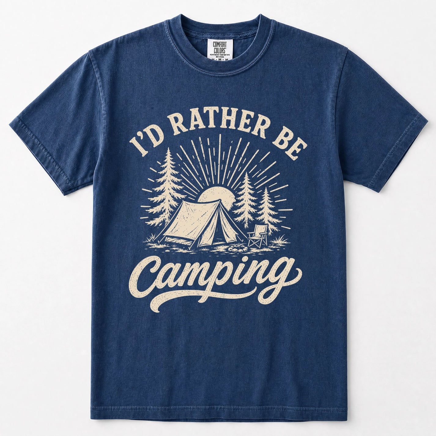 Navy blue short-sleeve crewneck t-shirt with a cream-colored graphic print on the front. The graphic features the text 'I'D RATHER BE Camping' in a stylized font, surrounding an illustration of a camping tent, pine trees, and a sunburst.