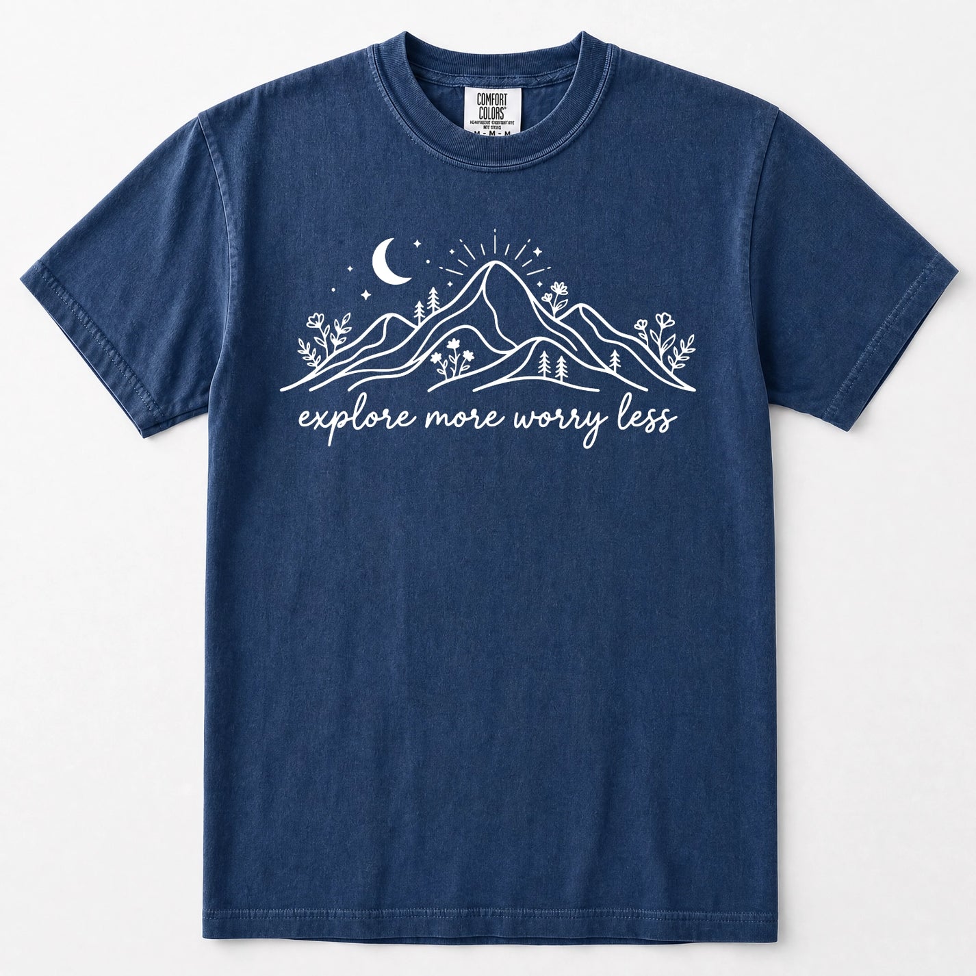 Navy blue short-sleeve crewneck t-shirt with a white graphic of mountains, a crescent moon, stars, and the text 'explore more worry less' printed on the front.