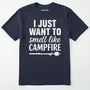 Navy i just want to smell like campfire t-shirt with a marshmallow on a stick graphic on a white background.