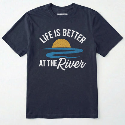 Navy river shirt with 'life is better at the river' design, paired with brown boots and a green backpack on a light grey background.