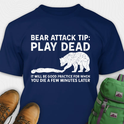 Navy blue bear tee shirt with bear graphic and text, placed on a white background with shoes and a backpack.