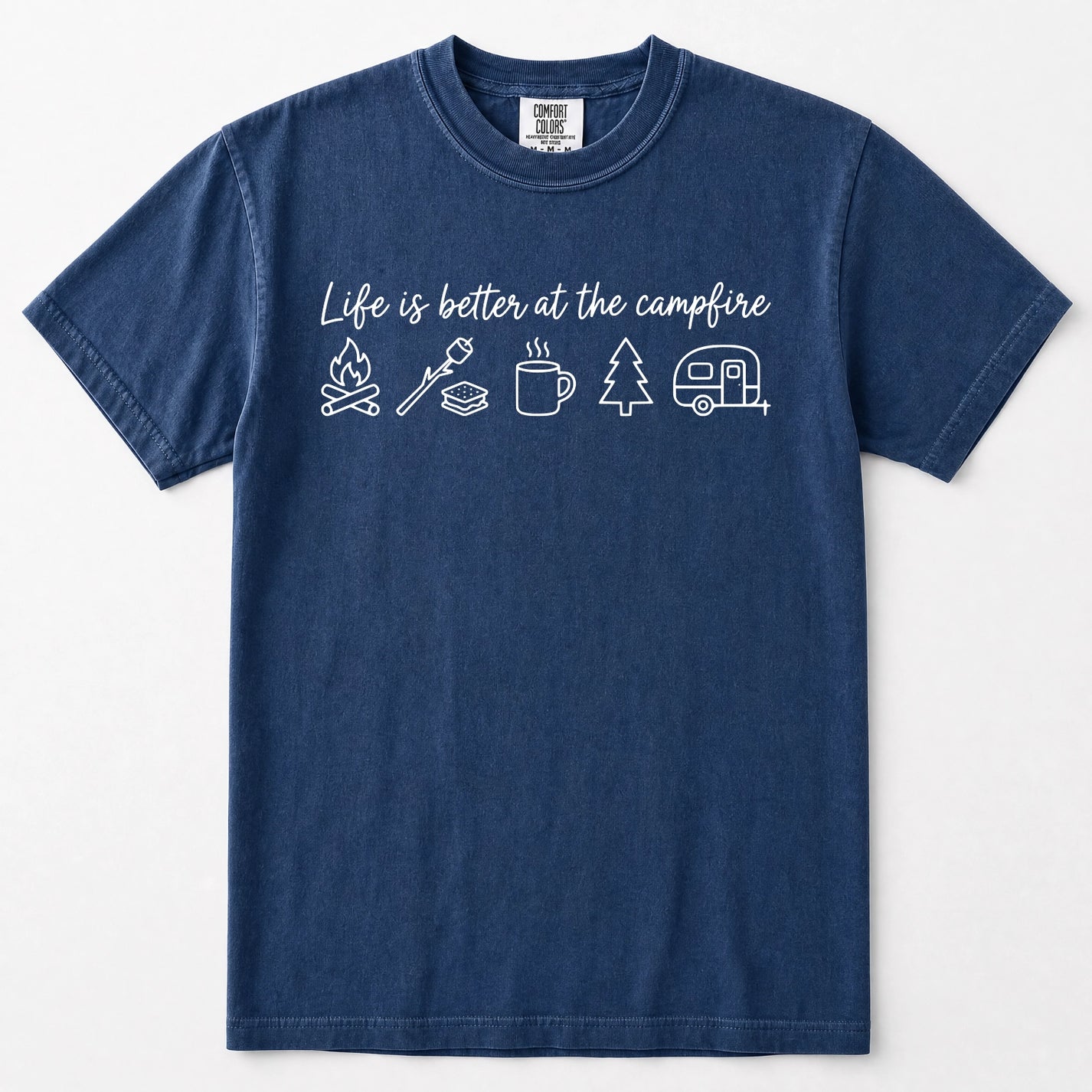 Navy blue short-sleeve crewneck t-shirt with a white graphic print on the chest that reads 'Life is better at the campfire' above simple line drawings of a campfire, roasting marshmallow, mug, pine tree, and camper trailer.