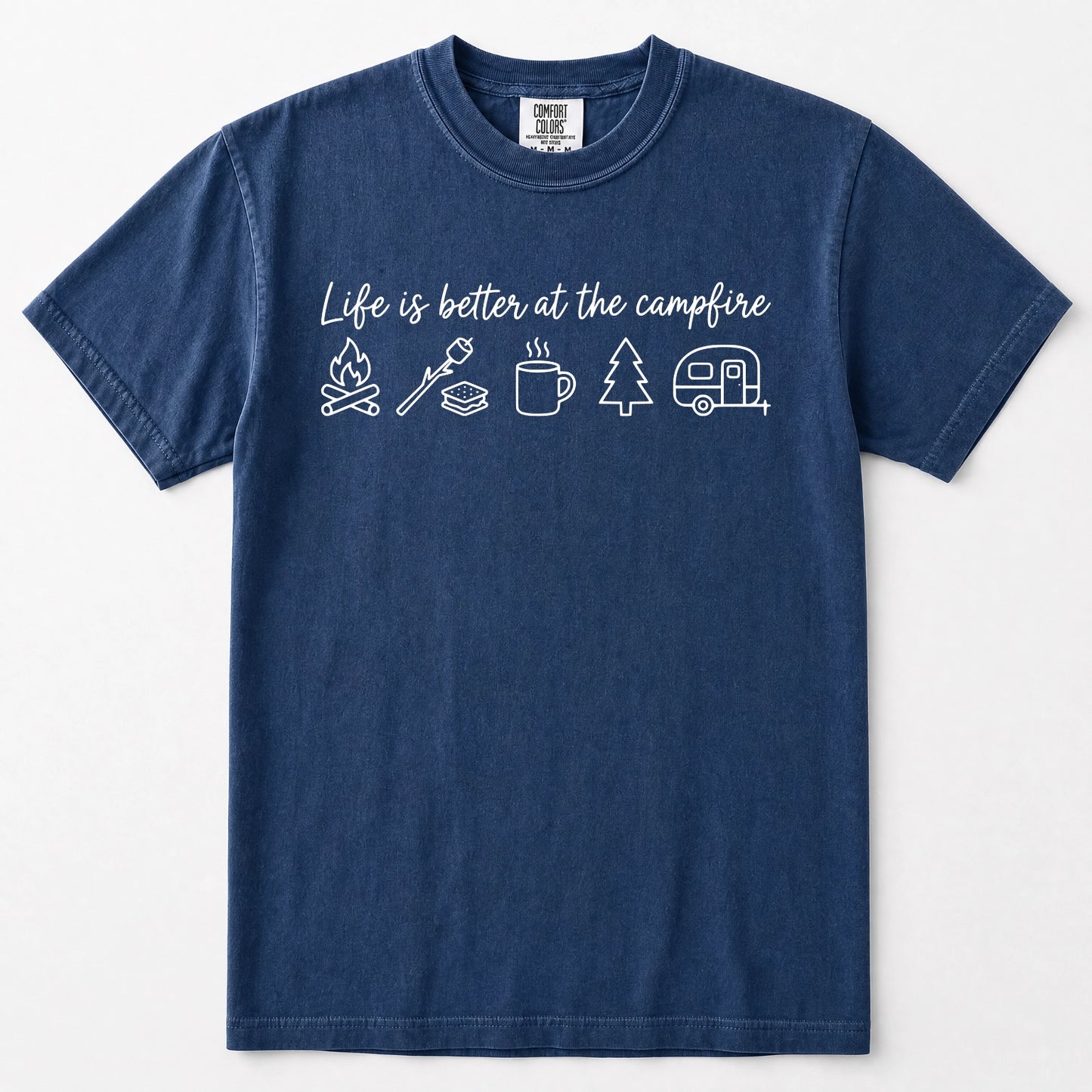 Navy blue short-sleeve crewneck t-shirt with a white graphic print on the chest that reads 'Life is better at the campfire' above simple line drawings of a campfire, roasting marshmallow, mug, pine tree, and camper trailer.