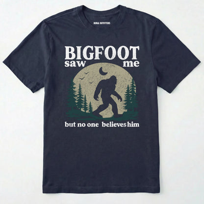Navy bigfoot saw me shirt with a vintage outdoor sasquatch in the forest graphic on a white background.
