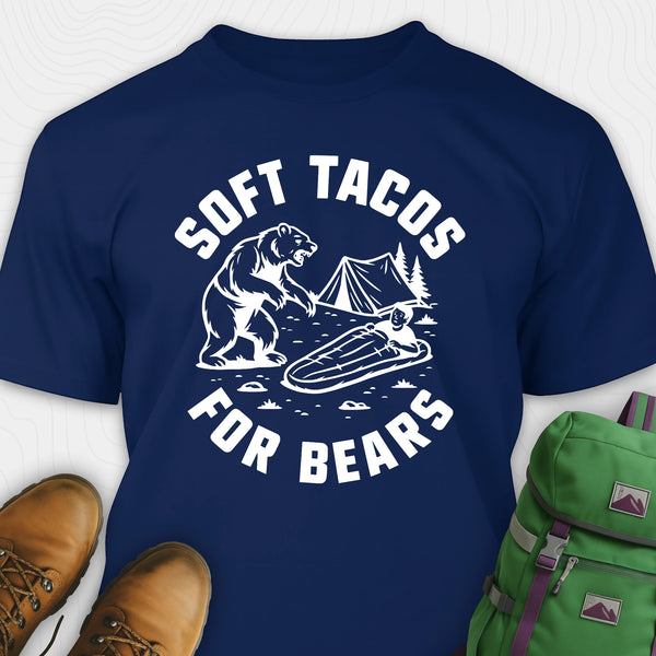 Navy funny bear shirt with bear graphic and text 'Soft Tacos for Bears' on a white background. surrounded by hiking boots and a green backpack.