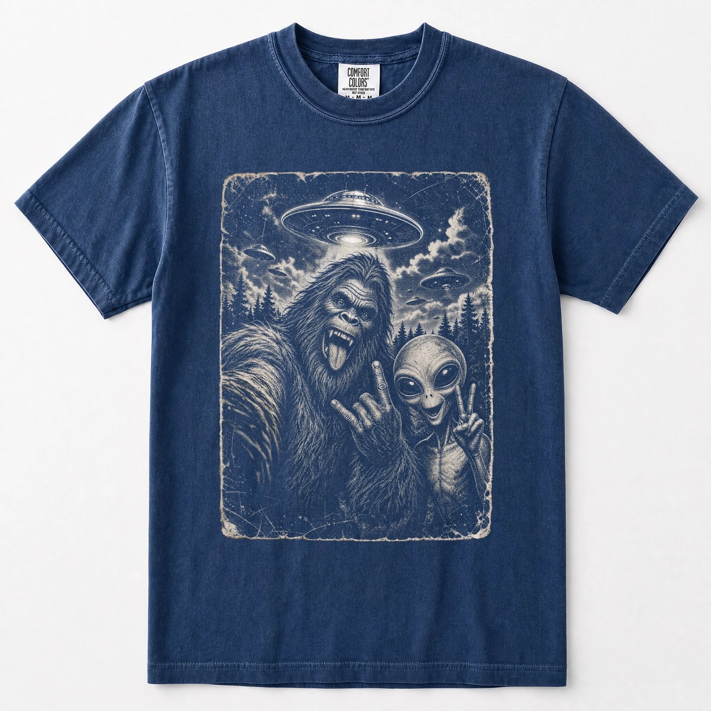 Navy blue short-sleeve crewneck t-shirt featuring a large graphic print on the front of a Bigfoot and an alien taking a selfie under a UFO.