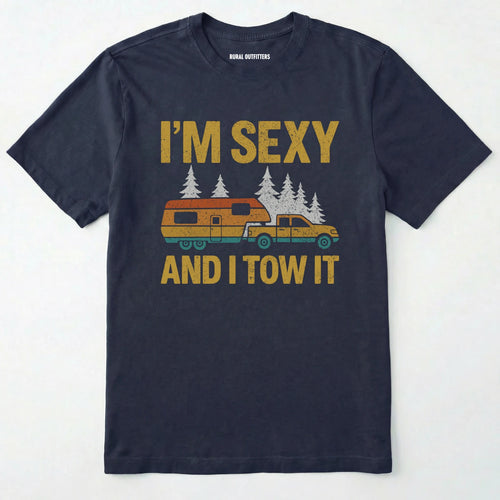 Navy fifth wheel t-shirt with “I’m Sexy and I Tow It” in distressed yellow text and a retro truck towing a camper graphic.