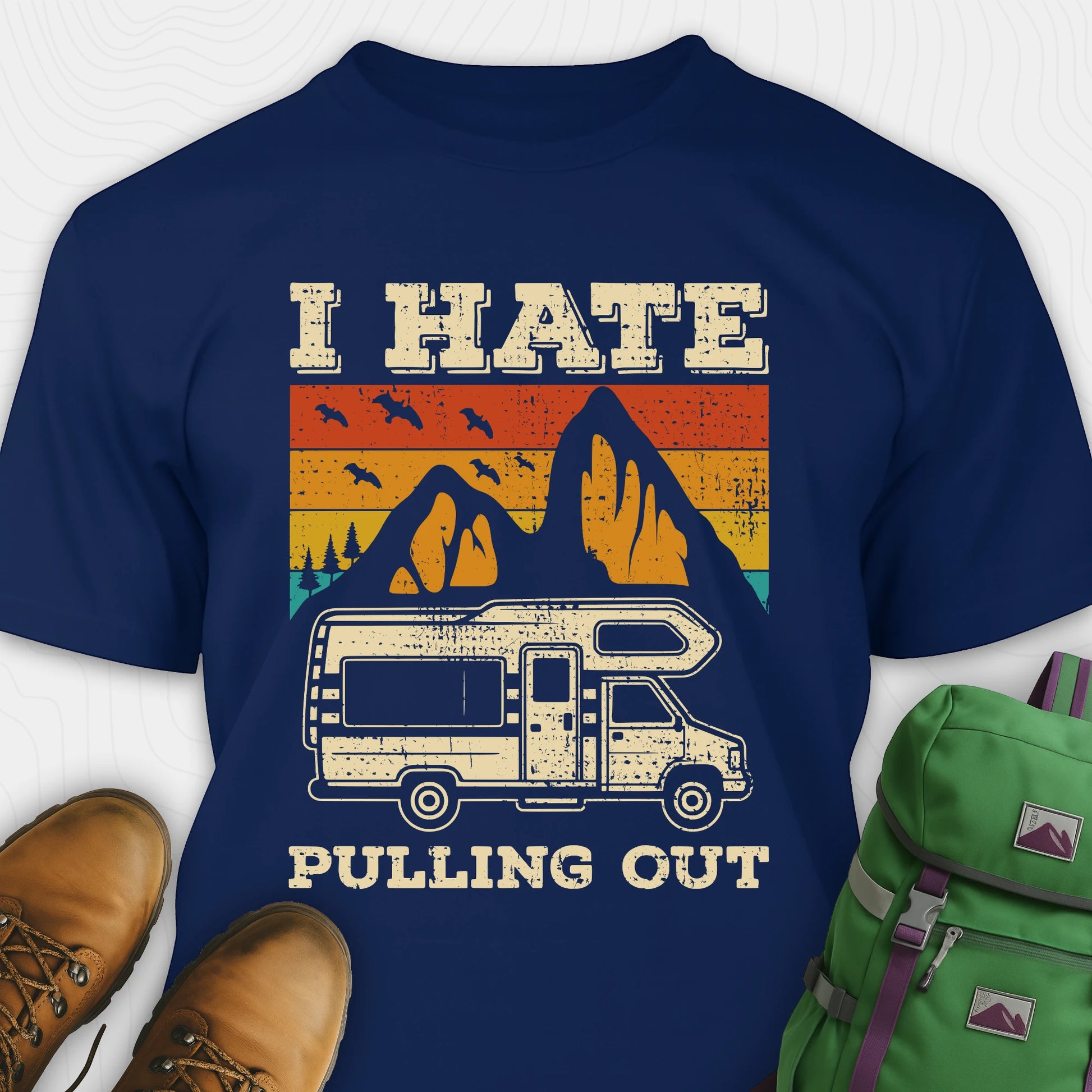 Navy I hate pulling out shirt with a graphic design of an RV and mountains, displayed with brown boots and a green backpack.
