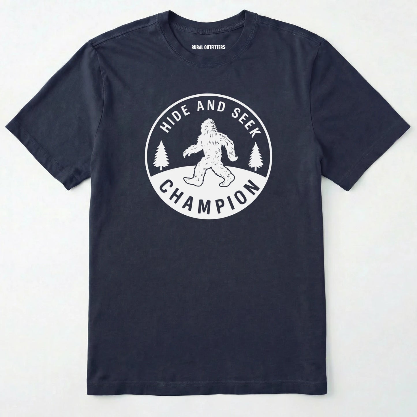 Navy bigfoot hide and seek champion shirt with forest emblem on a white background.