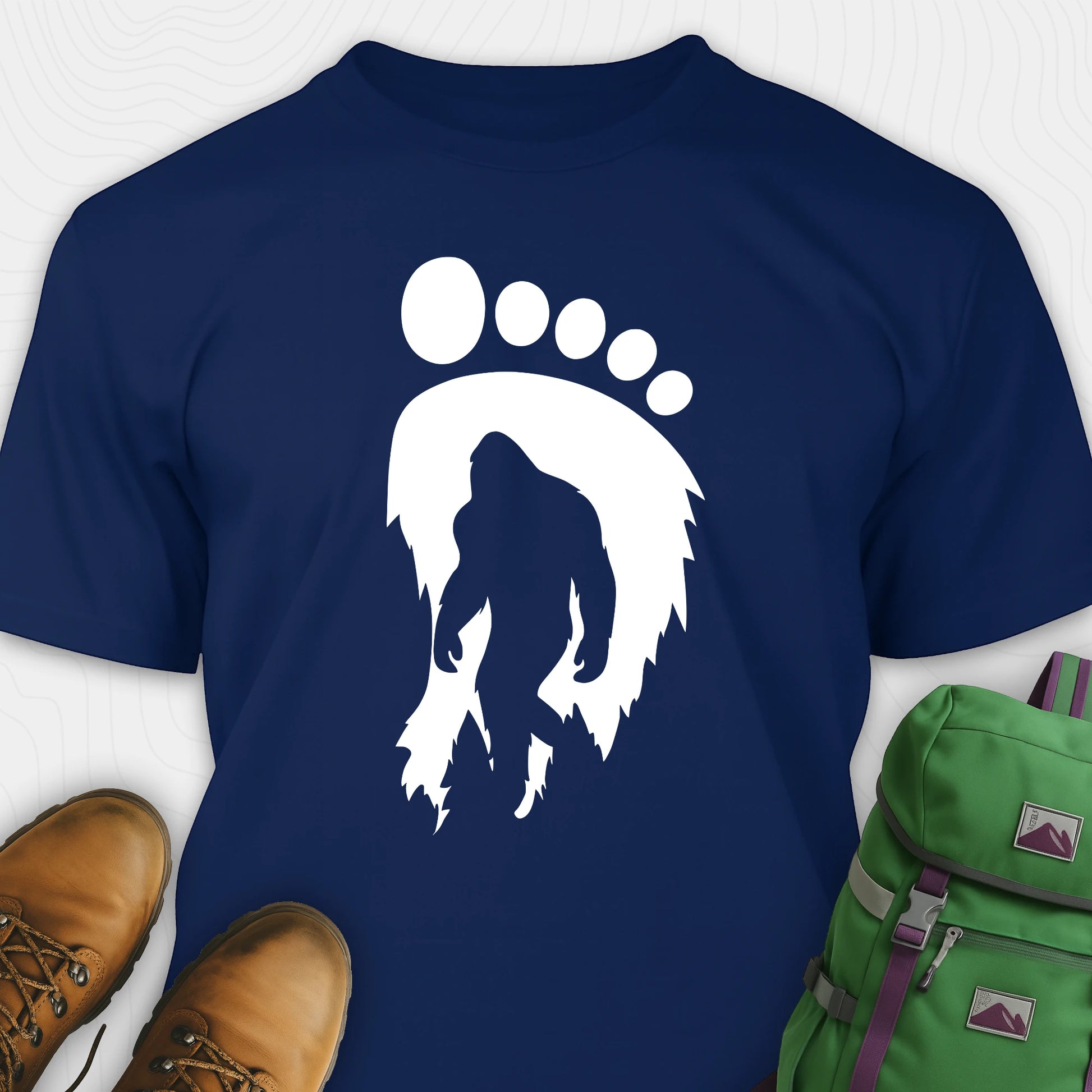 Navy bigfoot t-shirt with cryptid themed footprint graphic and sasquatch silhouette