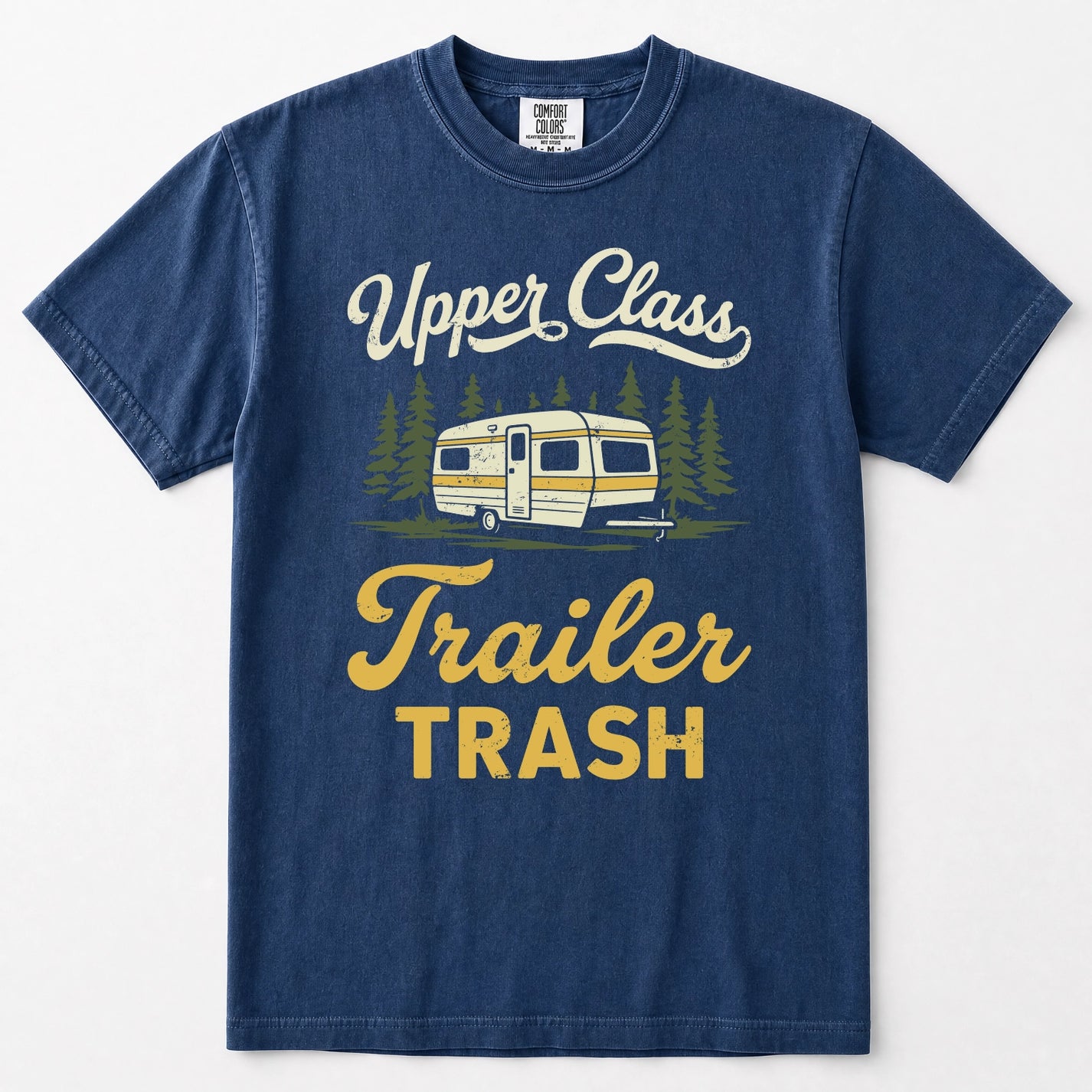 Navy blue short-sleeve t-shirt with a vintage-style graphic on the front featuring the text 'Upper Class Trailer TRASH' in white and yellow, alongside an illustration of a retro camper trailer and pine trees.