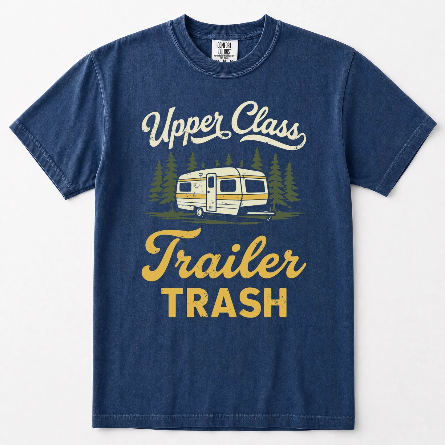 Navy blue short-sleeve t-shirt with a vintage-style graphic on the front featuring the text 'Upper Class Trailer TRASH' in white and yellow, alongside an illustration of a retro camper trailer and pine trees.
