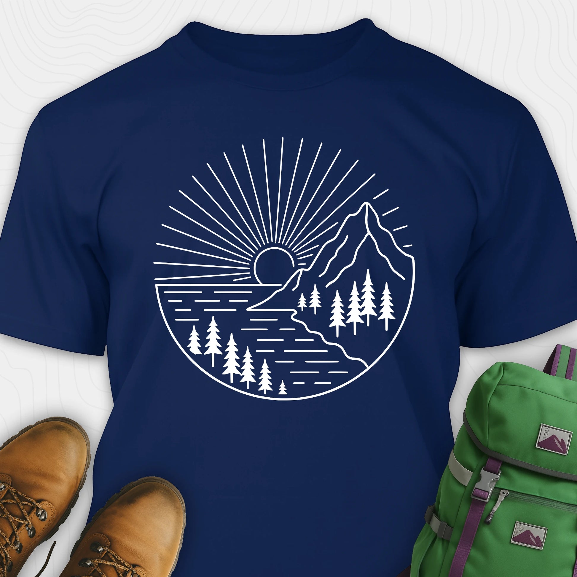 Navy mountain t-shirt with a white line-art design of mountains, trees, and a sunrise.