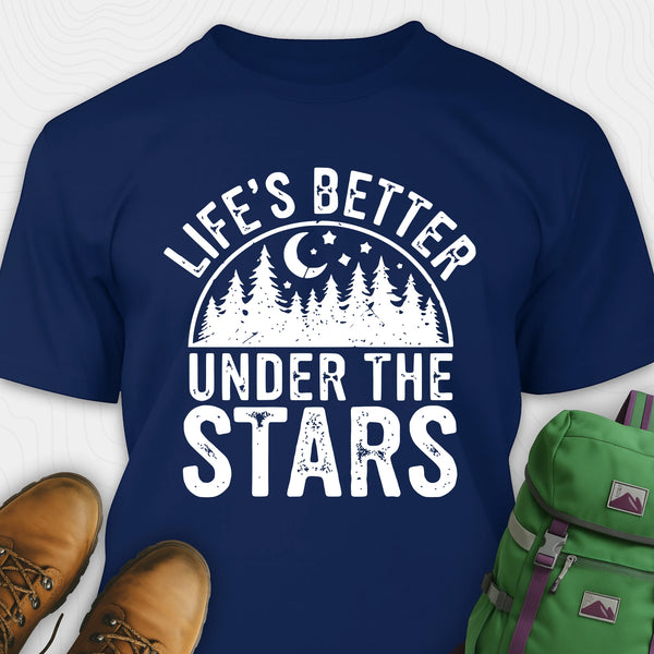 Navy blue Life's Better Under the Stars t-shirt with forest and moon graphic, paired with brown boots and a green backpack on a white background.