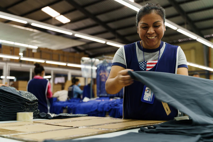 Woman working in a textile factory, examining fabric.