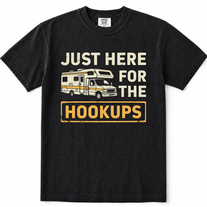 Black short-sleeve crewneck t-shirt with a vintage-style graphic print on the front. The graphic features the text 'JUST HERE FOR THE HOOKUPS' in distressed cream and yellow lettering, accompanied by an illustration of a cream and yellow camper van.