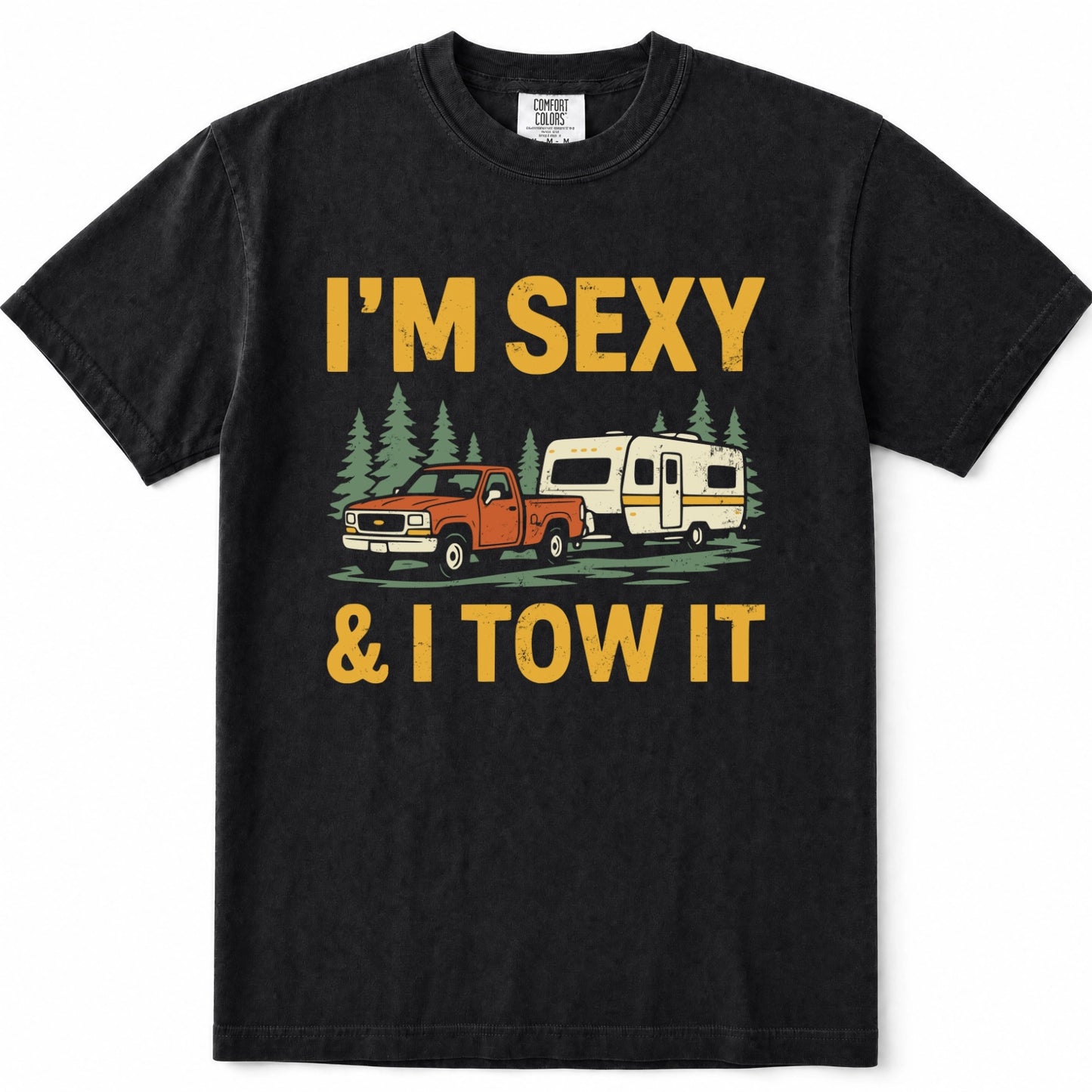 Black short-sleeve crewneck t-shirt with a vintage-style graphic print that reads 'I'M SEXY & I TOW IT' in yellow text, featuring an illustration of an orange pickup truck towing a cream camper trailer with green pine trees.