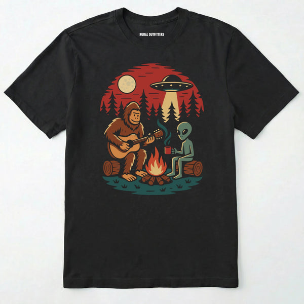 Black alien shirt with ufo, bigfoot camping by the fire design on a white background.