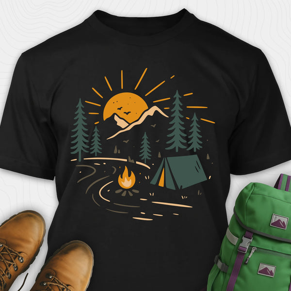 Black wilderness explorer shirt with sunset campfire scene with tent, trees, and mountains design