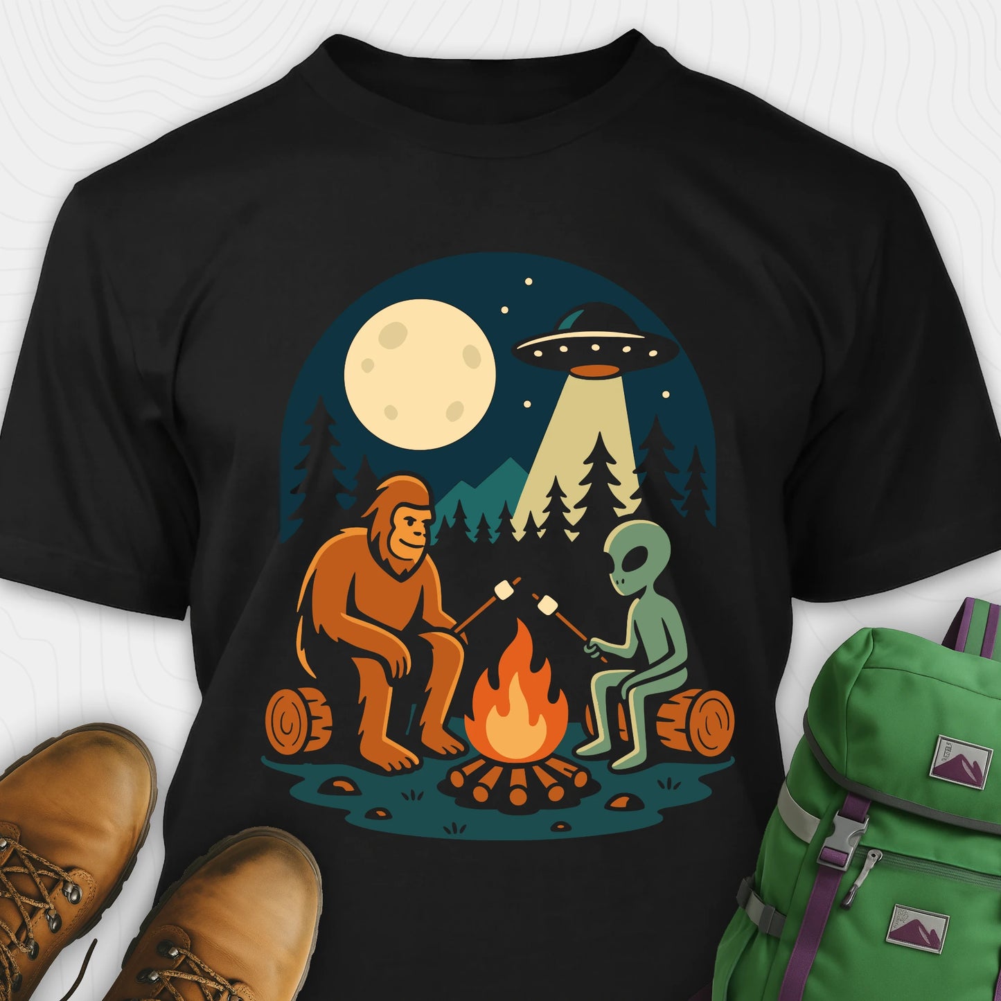 Black Bigfoot and alien shirt, featuring a sasquatch and a alien roasting marshmallows around a campfire with moon and UFO graphic