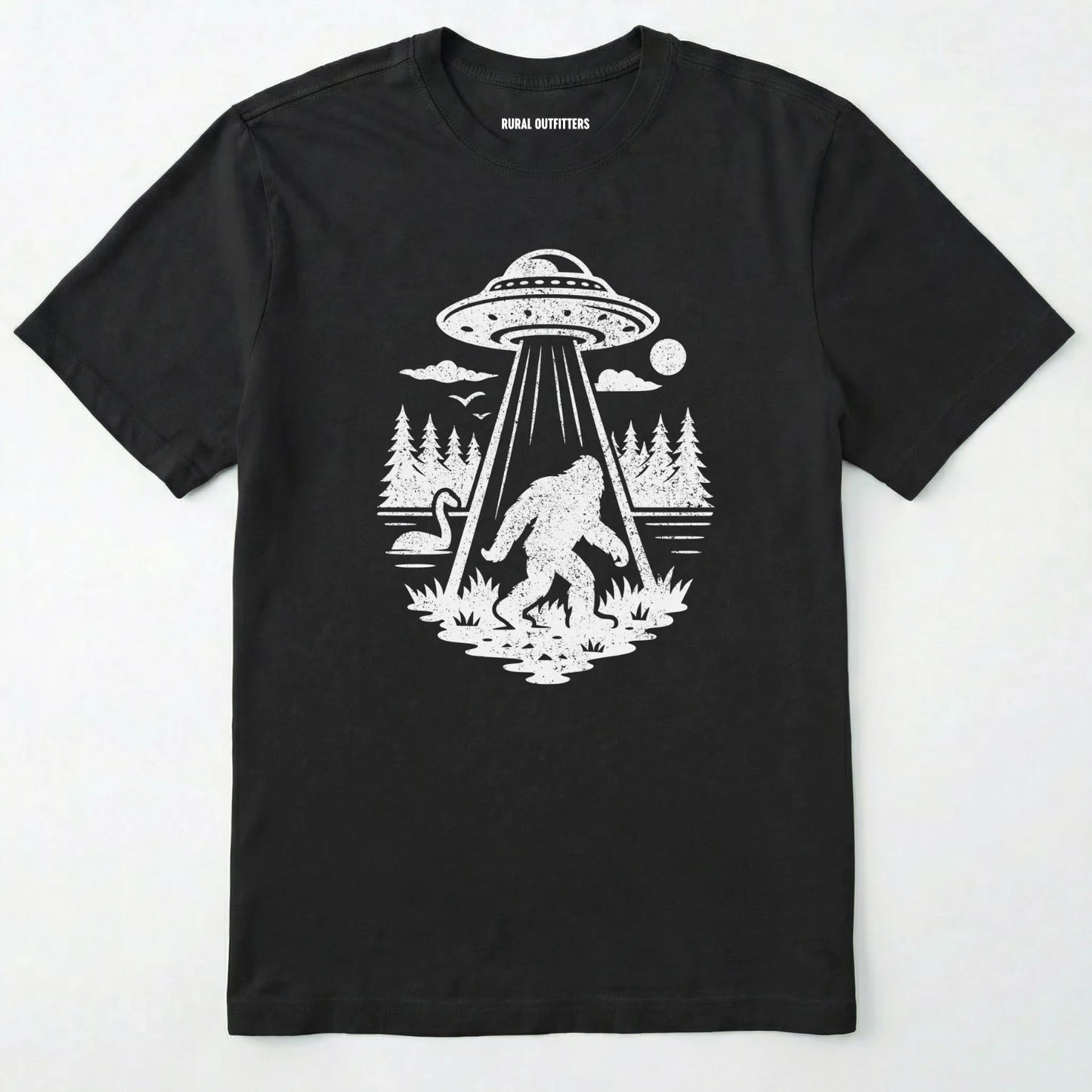 Black monster shirt with Bigfoot, a forest scene, and a UFO beam graphic on a white background.