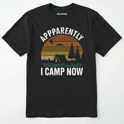 Black t-shirt with ⊜apparently i camp now⊝ in white text and a vintage sunset camping scene on a white background.