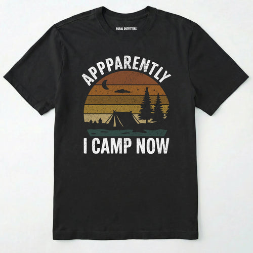 Black t-shirt with ⊜apparently i camp now⊝ in white text and a vintage sunset camping scene on a white background.