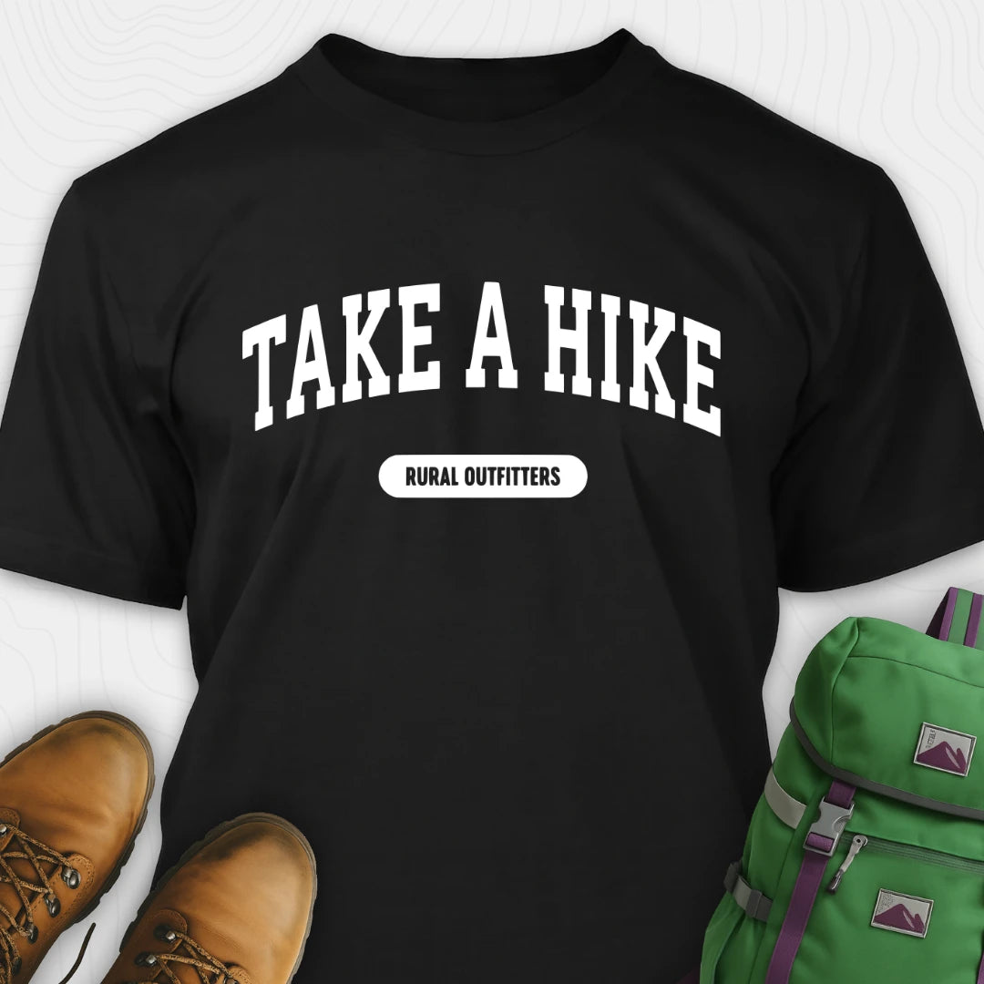 Black t-shirt with 'Take a Hike' text, brown boots, and green backpack on a white background