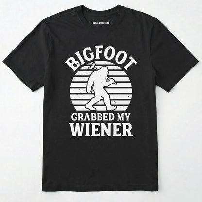 Black bigfoot grabbed my wiener t-shirt with a funny design and text, on a plain white background.