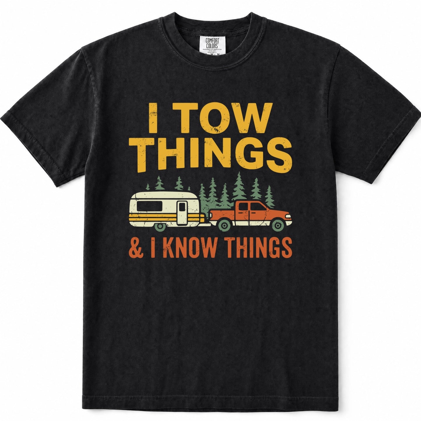Black short-sleeve crewneck t-shirt with a vintage-style graphic print. The graphic features the text 'I TOW THINGS' in yellow, a vintage camper trailer and orange pickup truck towing pine trees, and '& I KNOW THINGS' in orange.