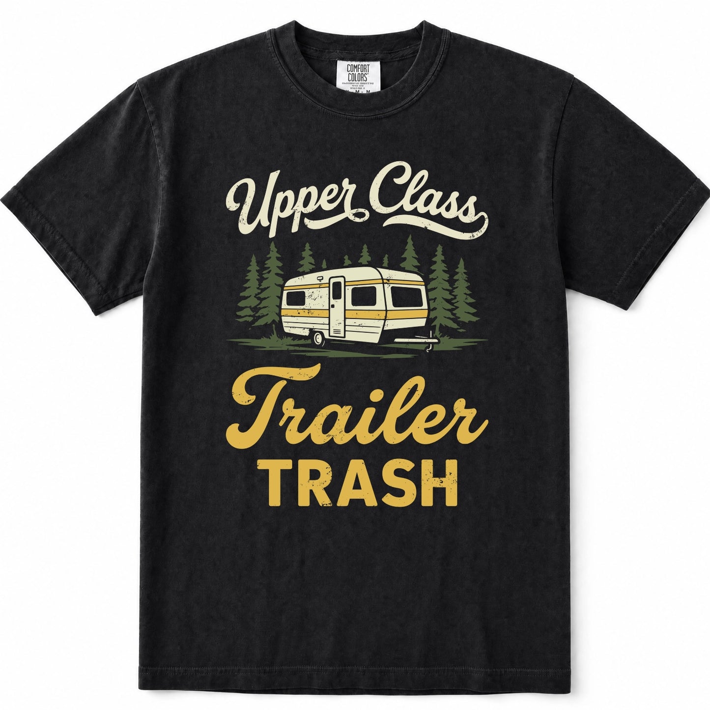 Black short-sleeve crewneck t-shirt with a vintage-style graphic print featuring the text 'Upper Class Trailer TRASH' in cream and yellow, alongside an illustration of a cream and yellow camper trailer surrounded by green pine trees.